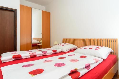 Dos camas en un dormitorio con flores. en Apartments Esad, en Kornić