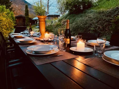 a wooden table with candles and a bottle of wine at Chalet Greystone in Brides-les-Bains