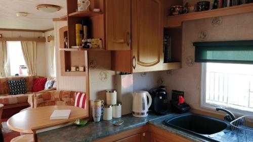 a kitchen with a sink and a table in a room at 8 Berth Sealands (Highbury) in Ingoldmells