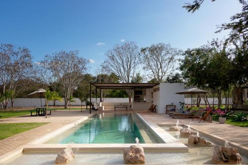 a swimming pool in a yard with a pavilion at Hotel Casa de Campo Conkal Merida in Conkal