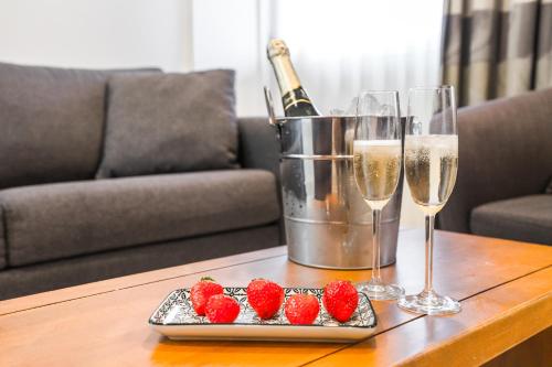 a table with two glasses of champagne and strawberries at Majestic City Suites & Beach Hotel in Willemstad