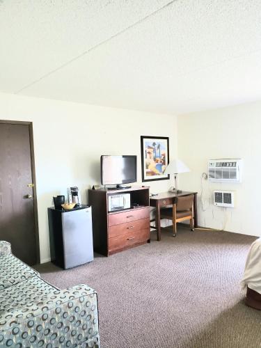a hotel room with a bed and a desk and a tv at M&M Motel in Connell