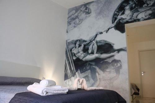 a bedroom with a bed with towels and a painting at Amantea Monument in Terrasini