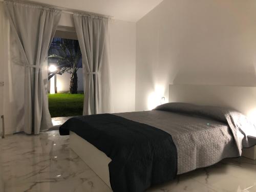 a bedroom with a bed and a window at Amantea Monument in Terrasini