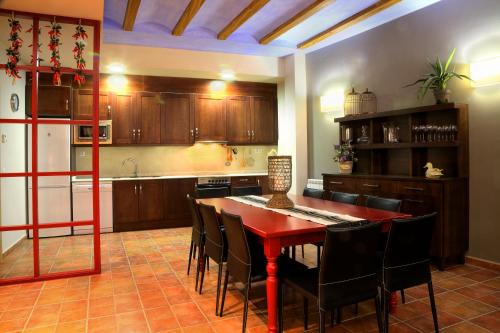 cocina con mesa roja y sillas negras en Apartamentos Casa Molinero, en Buera