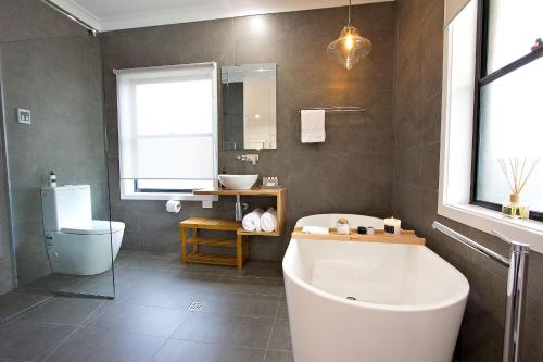 a bathroom with a tub and a toilet and a sink at The Clyde Greenock in Greenock