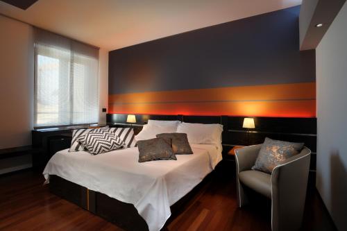 um quarto com uma cama e uma cadeira em Urban Trend - Guest House em Palmanova