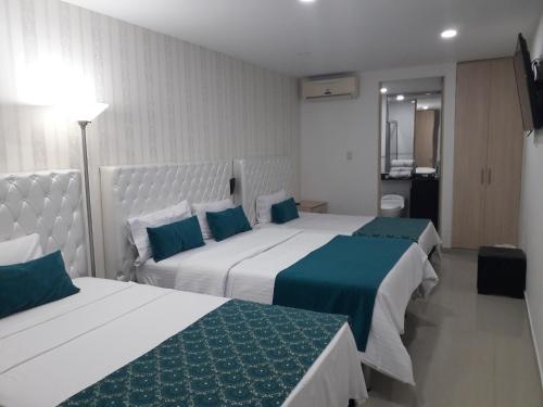 a hotel room with two beds with blue and white at Hotel Boutique El Poblado in Neiva