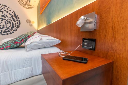 a bed with a table with a laptop on it at Shoshana Hotel Boutique in Buenos Aires