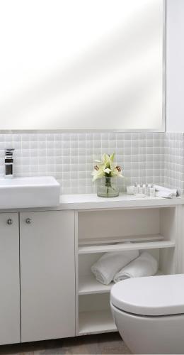 a white bathroom with a sink and a toilet at Studio 8 - Penthouse in Melbourne