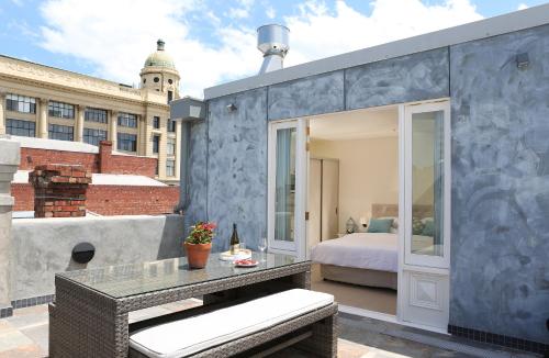 a room with a bed and a table on a balcony at Studio 8 - Penthouse in Melbourne