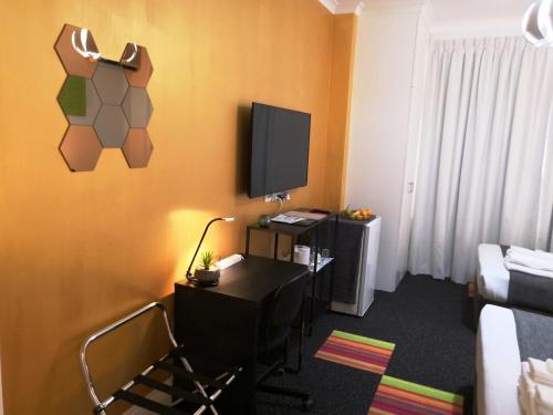 a room with a desk and a tv on the wall at Criterion Hotel Perth in Perth