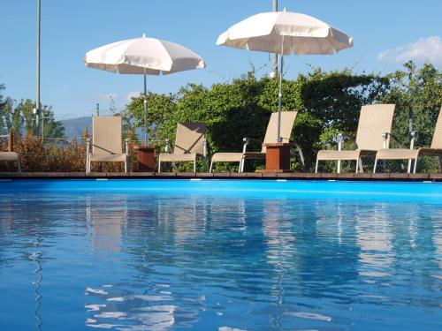 a group of chairs and umbrellas next to a swimming pool at Locanda Arizona in Bardolino