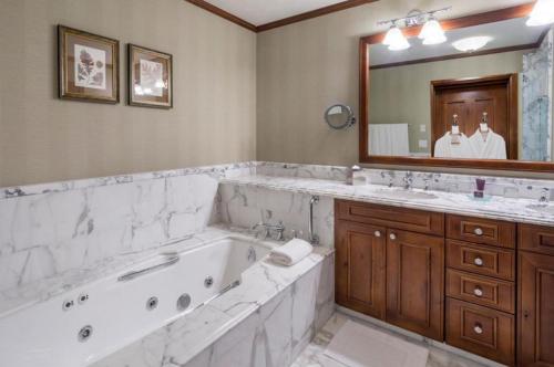 łazienka z dużą wanną i dużym lustrem w obiekcie The Ritz-Carlton Club, 3 Bedroom Residence Float 1, Ski-in & Ski-out Resort in Aspen Highlands w Aspen