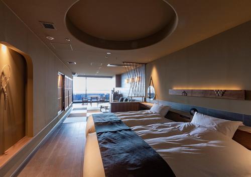 a bedroom with two beds and a large window at Lake Shikotsu Tsuruga Bessou AO no ZA in Chitose