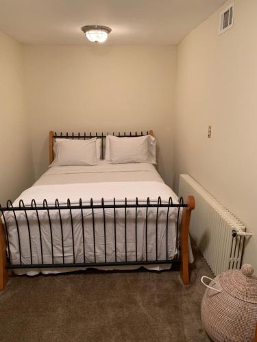 1 dormitorio con 1 cama con sábanas y almohadas blancas en Woody Westover in Hillcrest DC near Capitol Hill en Washington