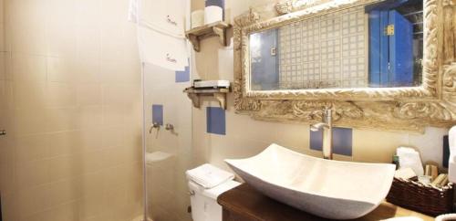 a bathroom with a sink and a mirror and a toilet at Alondra Hotel Boutique in Mineral del Monte