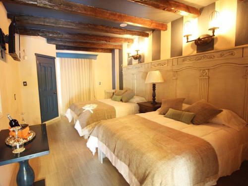 - une chambre avec deux lits et une table avec une lampe dans l'établissement Alondra Hotel Boutique, à Mineral del Monte