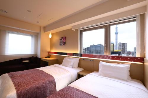 a hotel room with two beds and a window at Hotel Gracery Asakusa in Tokyo