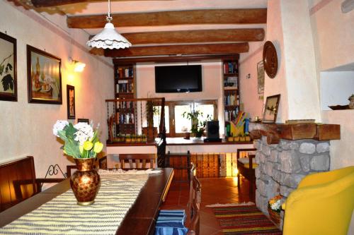 a living room with a table and a stone fireplace at La Giara Bed&Breakfast in Brienza