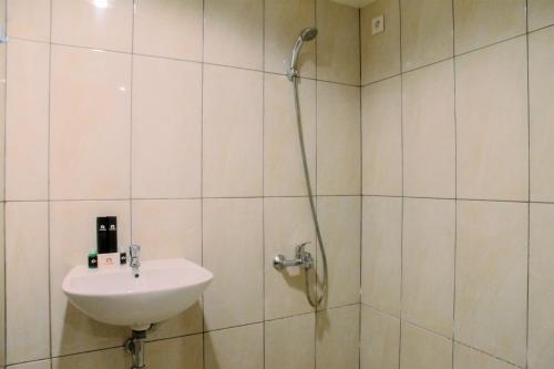 une salle de bain avec un lavabo et une douche dans l'établissement Vintage 2BR Apartment at Grand Kamala Lagoon By Travelio, à Pulosirih