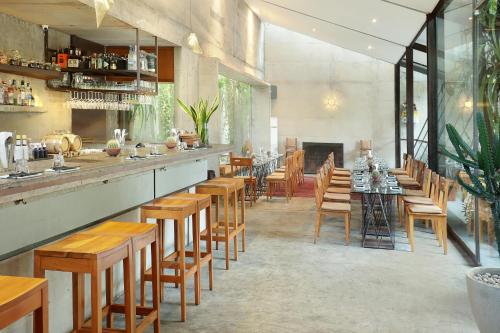 a restaurant with a bar with wooden tables and chairs at Uma Sapna Seminyak in Seminyak