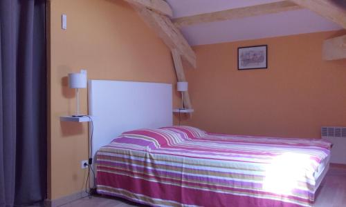 a bedroom with a bed with a striped blanket at saint trome in Espinas