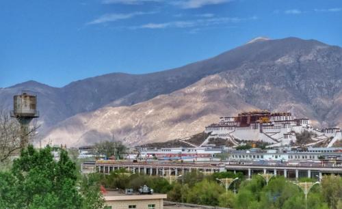uma vista para uma cidade com montanhas ao fundo em Gaisang Mêdog Aroma Fragrance Hotel em Lhasa