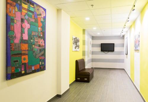 a waiting room with a chair and a painting on the wall at Art хостел-готель "Адреналін" in Luts'k