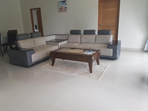 a living room with two couches and a coffee table at Maison Cattleya Selfcatering Apartment in Mahe