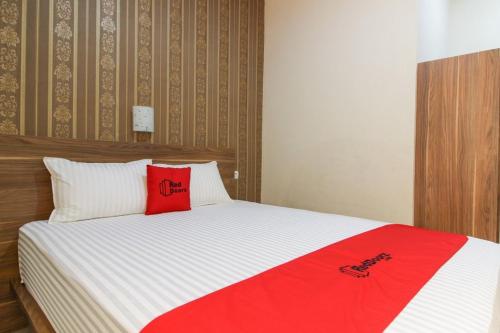 a bedroom with a bed with red pillows on it at RedDoorz near Jogja Kembali Monument 3 in Kalasan