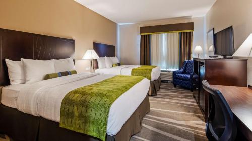 una camera d'albergo con due letti e una televisione di Best Western Plus Denver City Hotel & Suites a Denver City