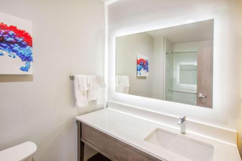 a white bathroom with a sink and a mirror at La Quinta by Wyndham Dallas Duncanville in Duncanville