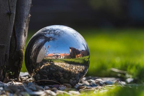 a reflection of a house in a glass ball in the grass at Haus Ilsegarten in Ilsenburg