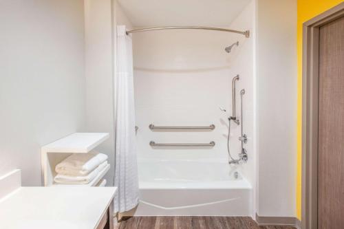 a bathroom with a shower and a white tub at La Quinta by Wyndham Dallas Duncanville in Duncanville