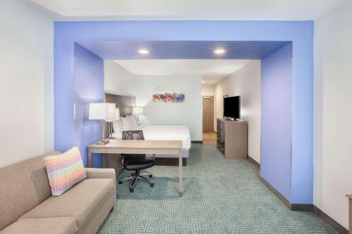 a hotel room with a bed and a desk at La Quinta by Wyndham Dallas Duncanville in Duncanville