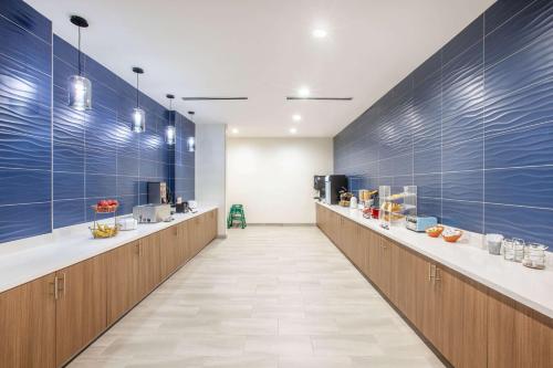 a cafeteria with blue walls and a long row of counters at La Quinta by Wyndham Dallas Duncanville in Duncanville
