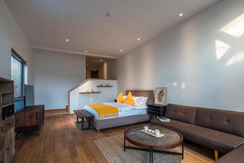 a living room with a bed and a couch at The Western Clouds in Deqing