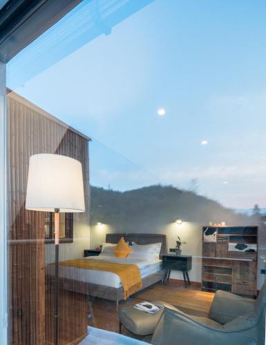 a bedroom with a bed and a large window at The Western Clouds in Deqing