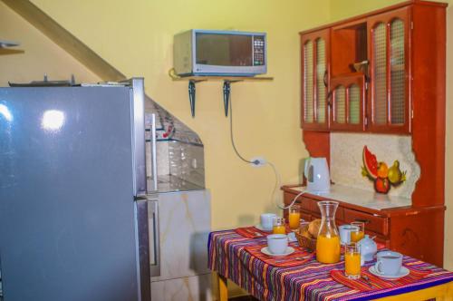 a kitchen with a table and a refrigerator at Residencial el Valle in Huaraz