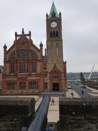 a large brick building with a clock tower with a cannon at LegenDerry B&B in Derry Londonderry
