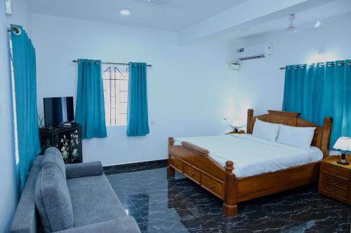 a bedroom with a bed and a couch and blue curtains at Lar Amorosa Studios in Sangolda