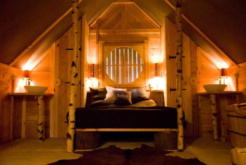 a bedroom with a bed in a room with lights at Cabane Lodge Domaine du Lac Chambon in Murol