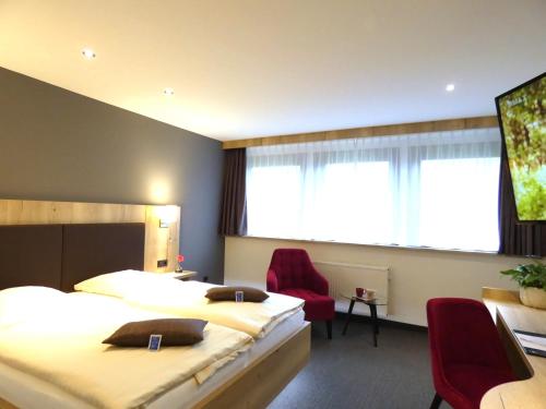 a hotel room with two beds and a window at Akzent Hotel Cordes & Restaurant am Rosengarten in Sottorf