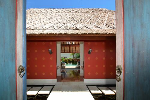 an open door to a building with a tile roof at Kama Village by Nakula in Sanur