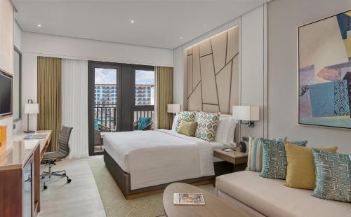 ダバオシティにあるdusitD2 Davaoのベッドとソファのあるホテルの部屋