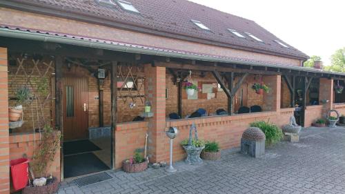 a brick building with potted plants on it at Pension Pawlak in Tauche