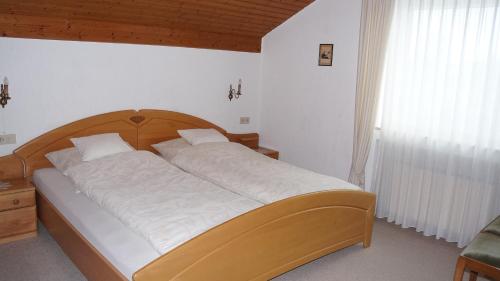 sypialnia z dużym łóżkiem z drewnianym zagłówkiem w obiekcie BodenSEE Apartment Langenargen Fliederweg w mieście Langenargen