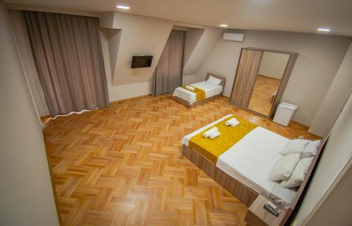 a large room with two beds and a mirror at NaNa's Guesthouse in Batumi