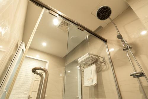 a shower in a bathroom with a glass shower stall at London Hotel in Ha Long